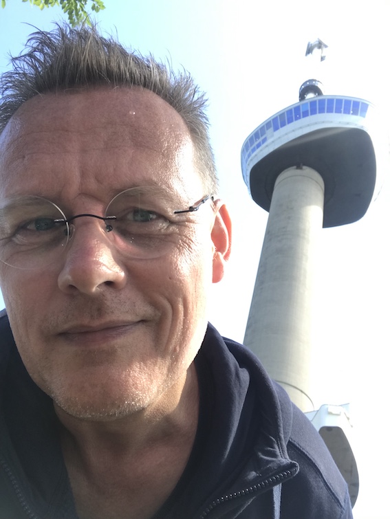 spectacled 50 year old guy standing near the Euromast in Rotterdam